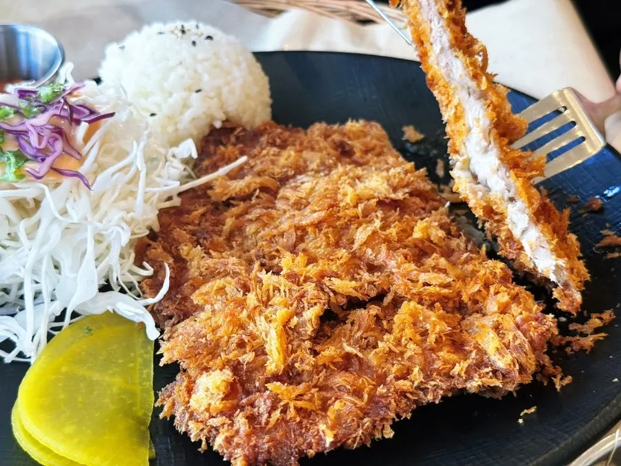 돈까스를 소스에 찍어 먹는 모습