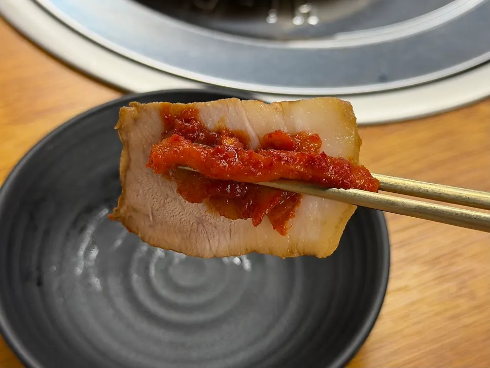 Boiled pork topped with pollack sashimi and radish slaw