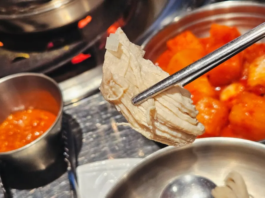 Close-up of dakgalbi cooking over charcoal