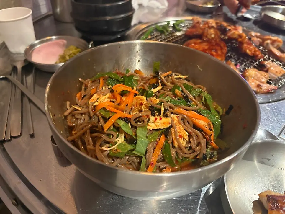 Mixing the tangy, sweet deulgye guksu noodles