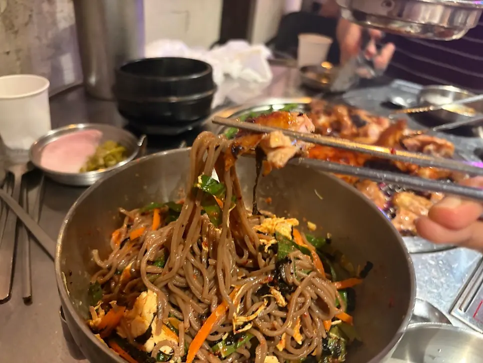 Close-up of a chopstick-full of deulgye guksu noodles
