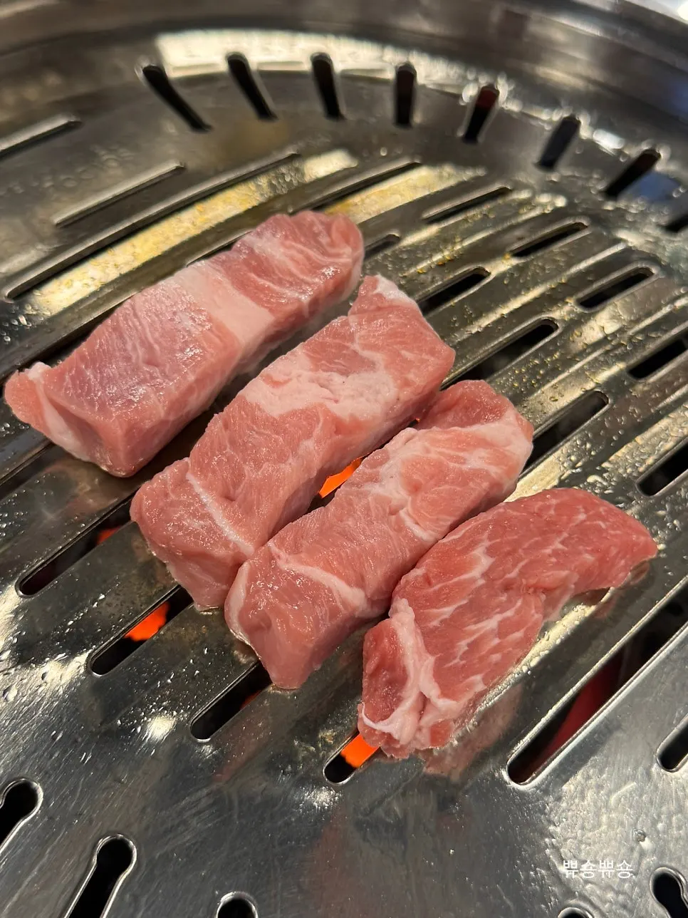 Signature pork neck grilling over charcoal