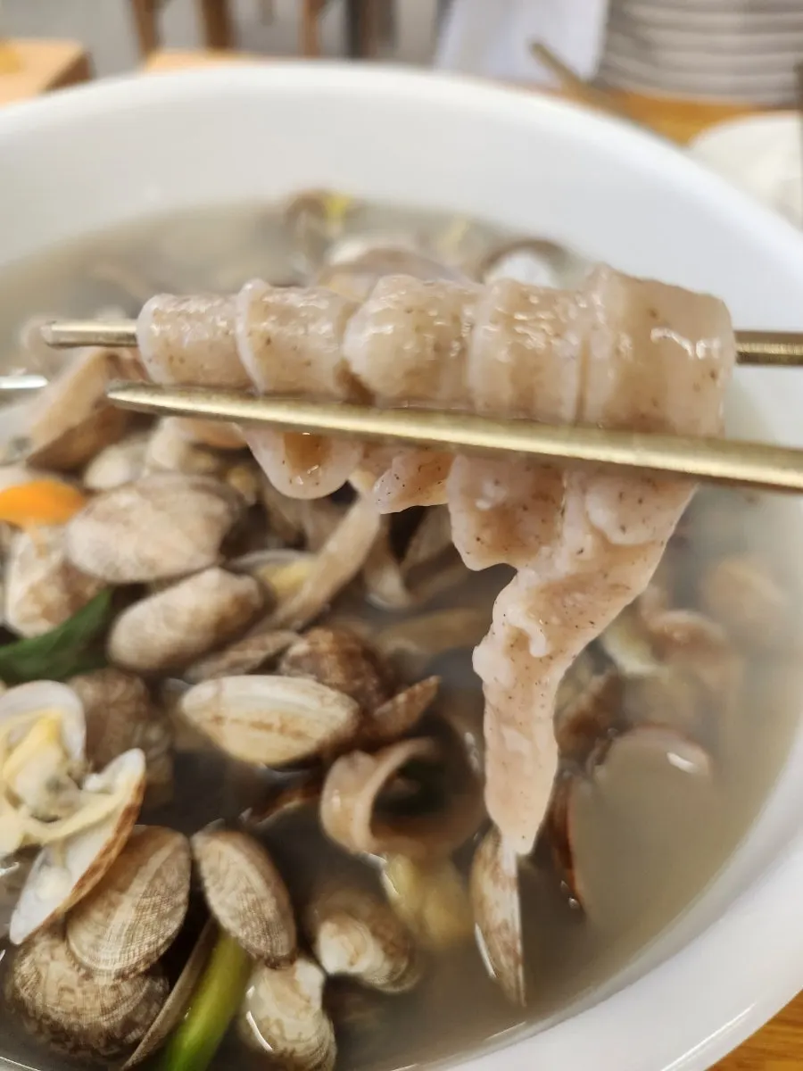 Buckwheat clam kalguksu with the pot piled full of clams