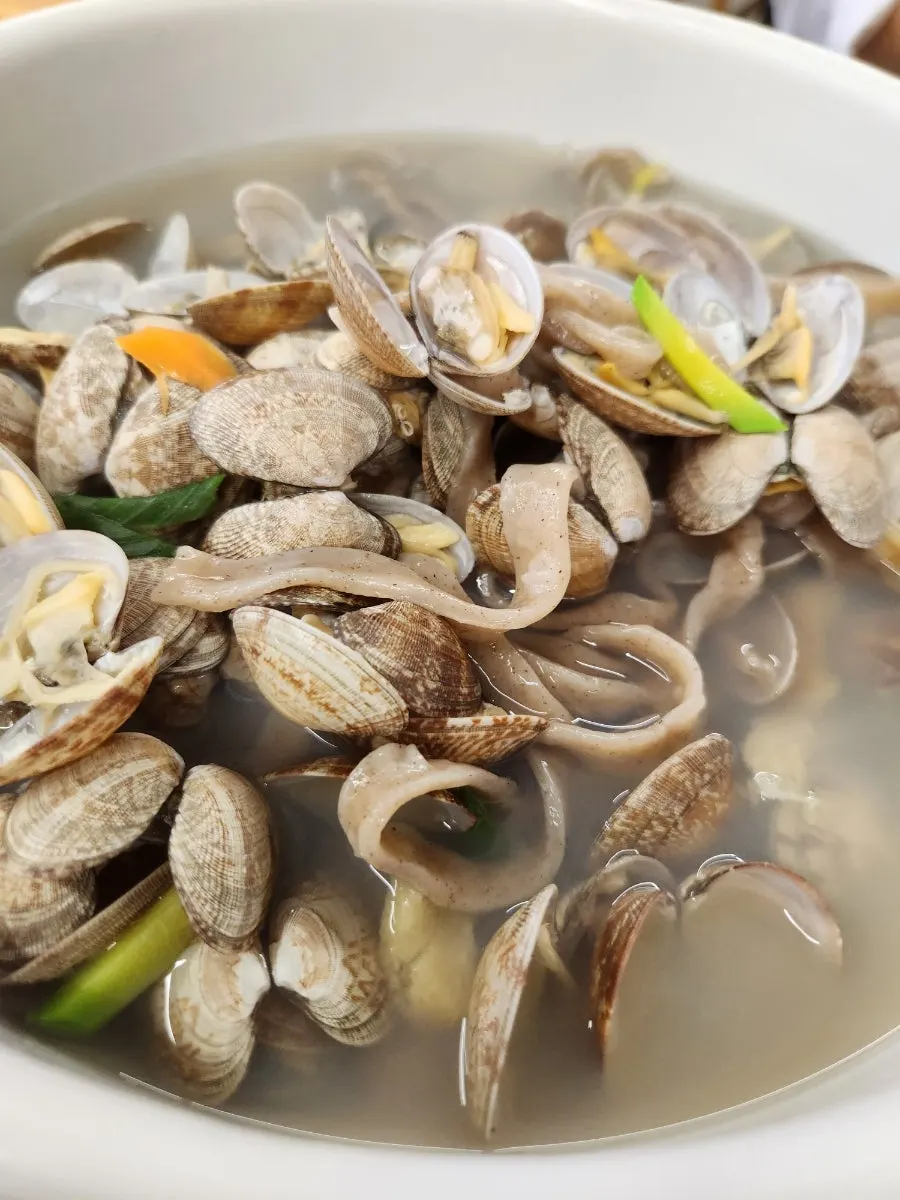 Clams and buckwheat kalguksu noodles scooped up with the broth