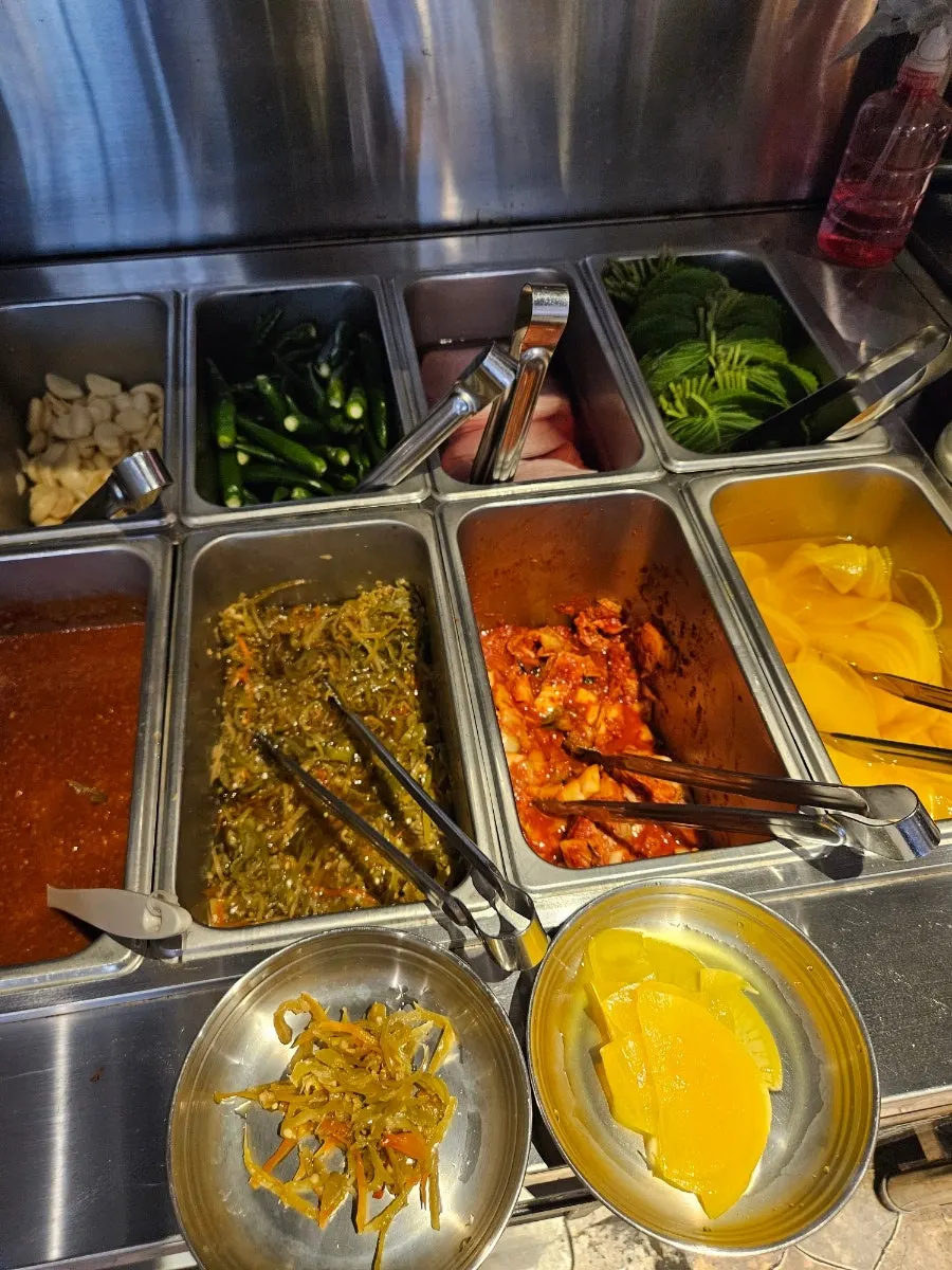 Plate of self-serve side dishes including pickled pepper strips