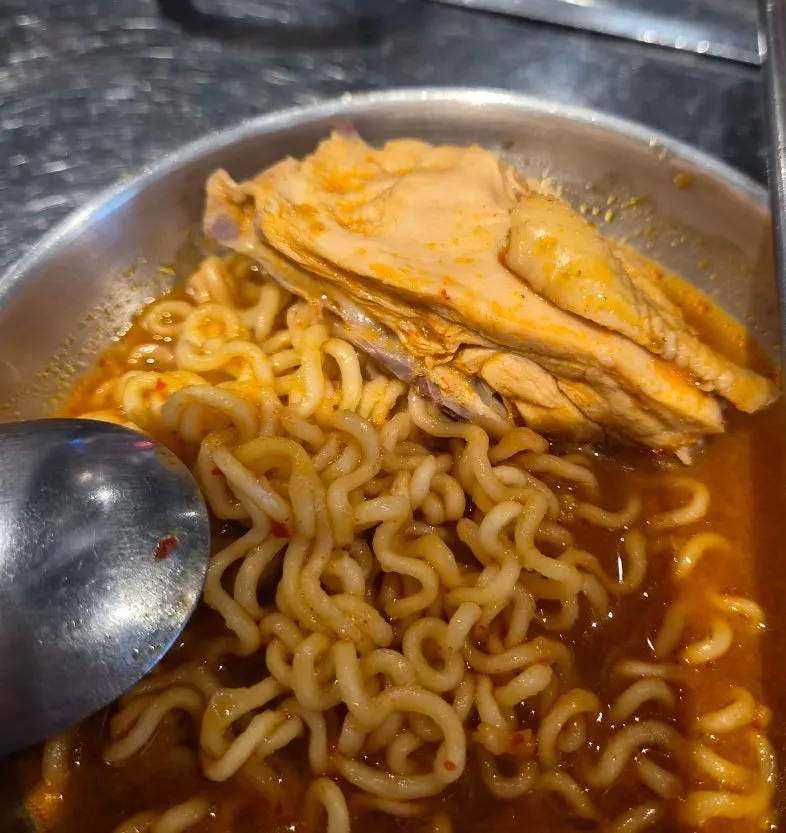 A chopstick's worth of ramen noodles served together with chicken