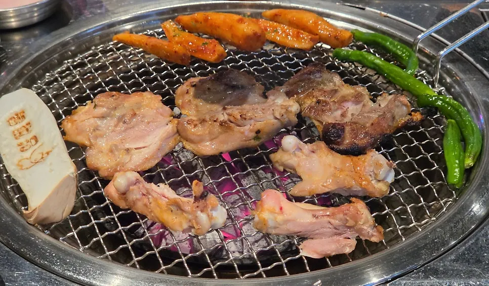 Dakgalbi being cut on the grill by a staff member