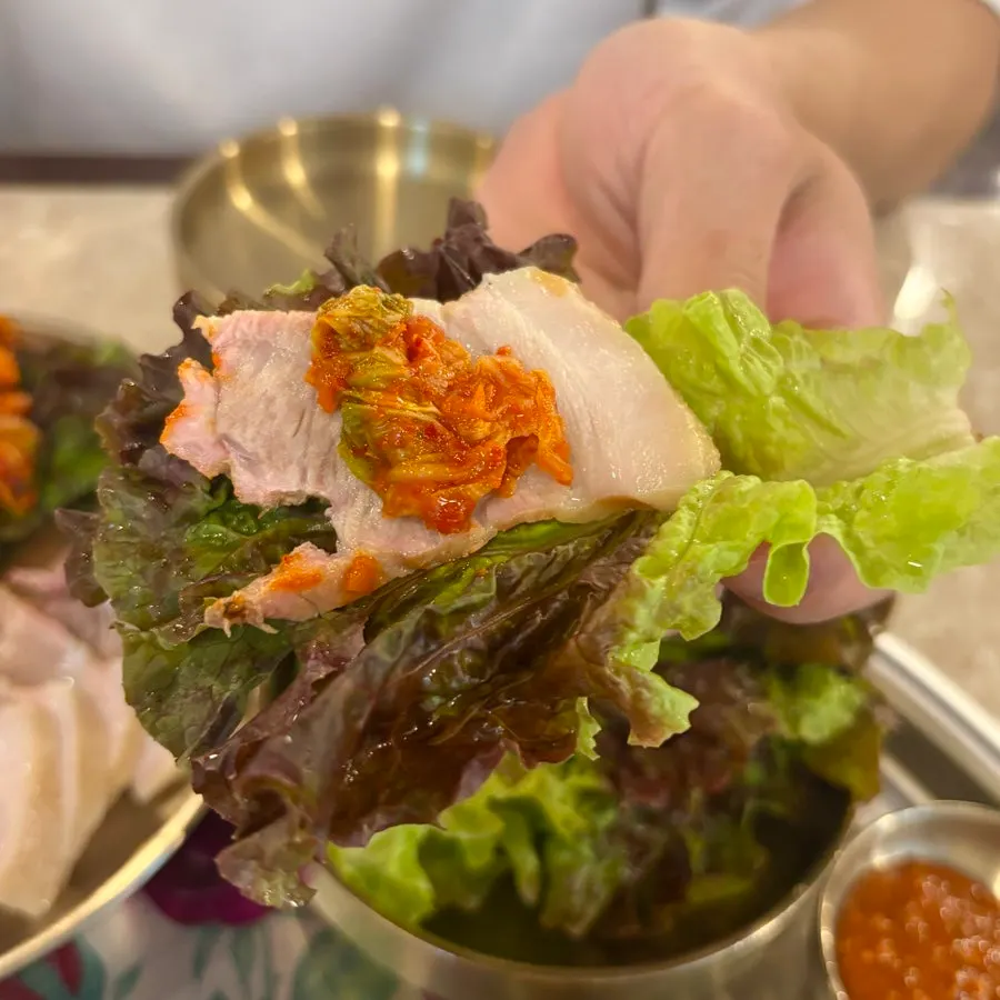 김치를 올린 양재옥 보쌈 한 점