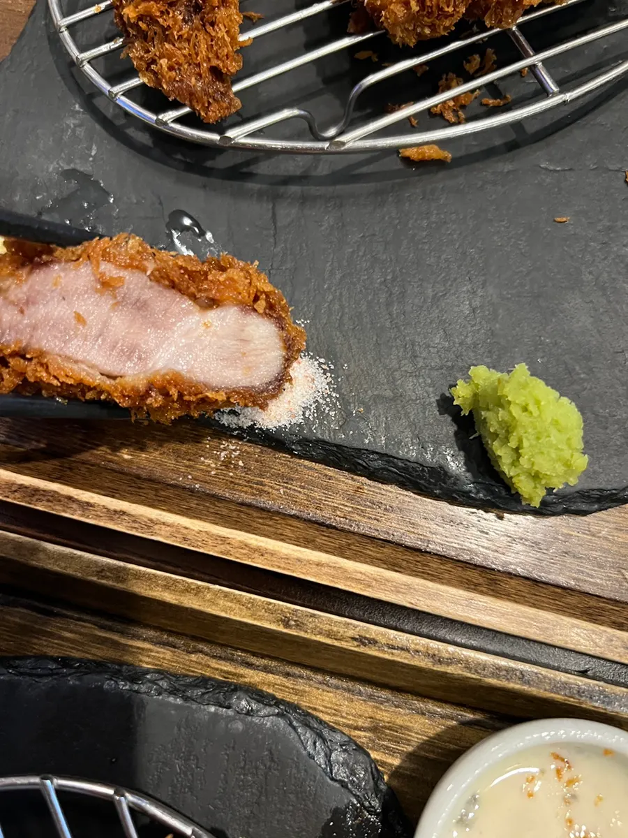 A piece of the special loin katsu picked up with chopsticks