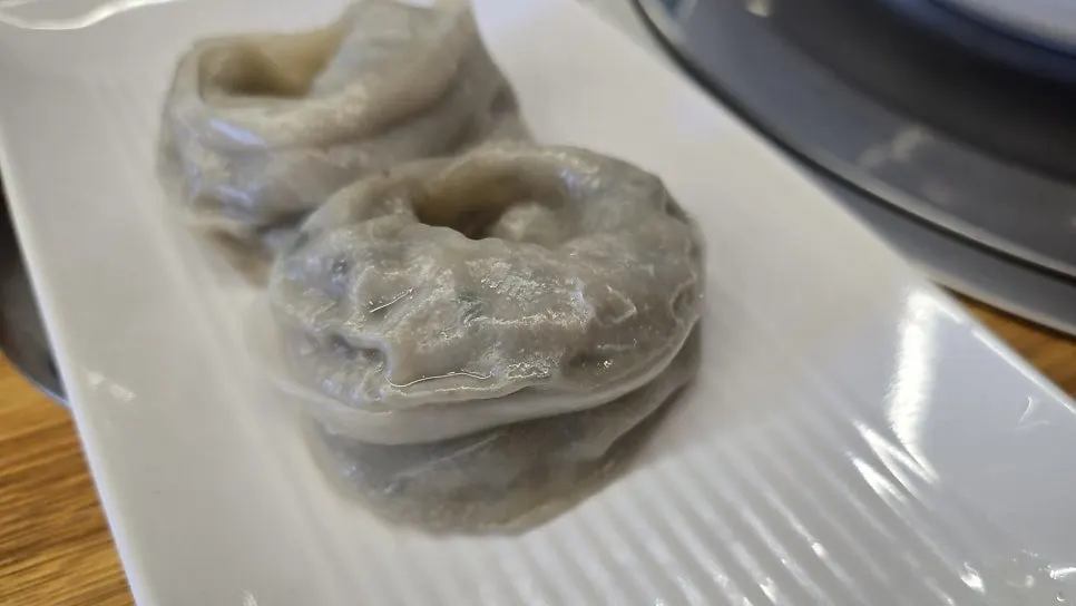 Plate of neungi mushroom-pork king mandu with grayish buckwheat wrappers