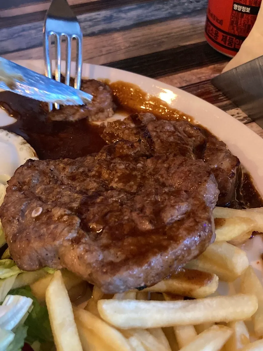 Pork neck steak served with rice and fries