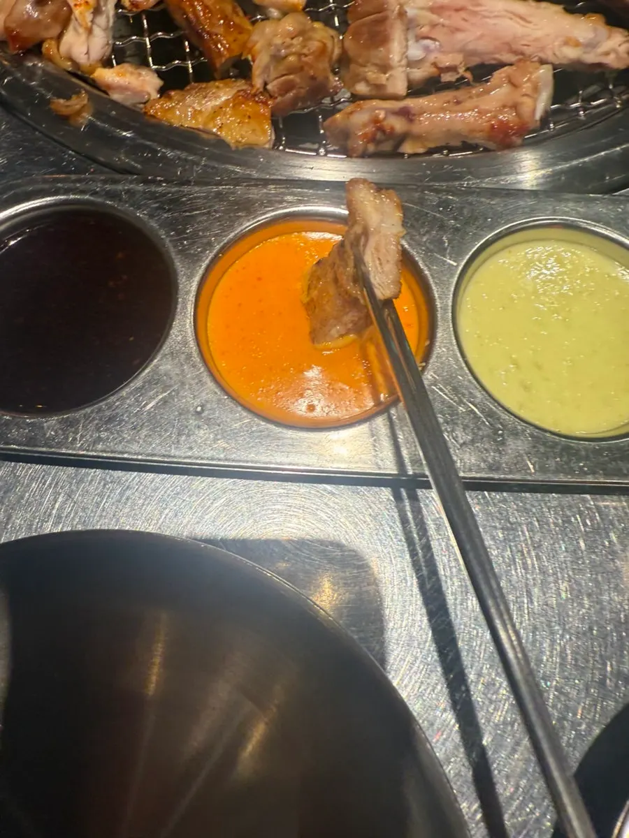 매콤 소스를 찍은 숯불 닭갈비