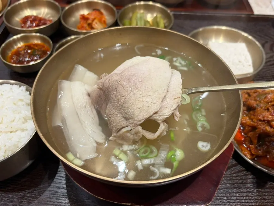 Clear pork gomtang served in a brass bowl