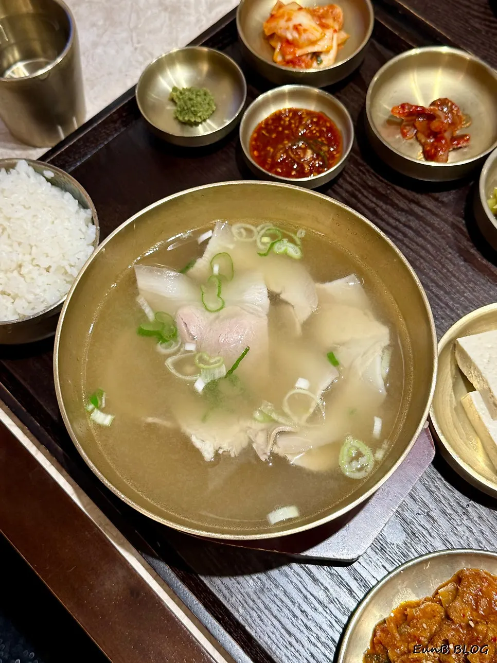 맑은 돼지곰탕과 보쌈이 놓인 테이블