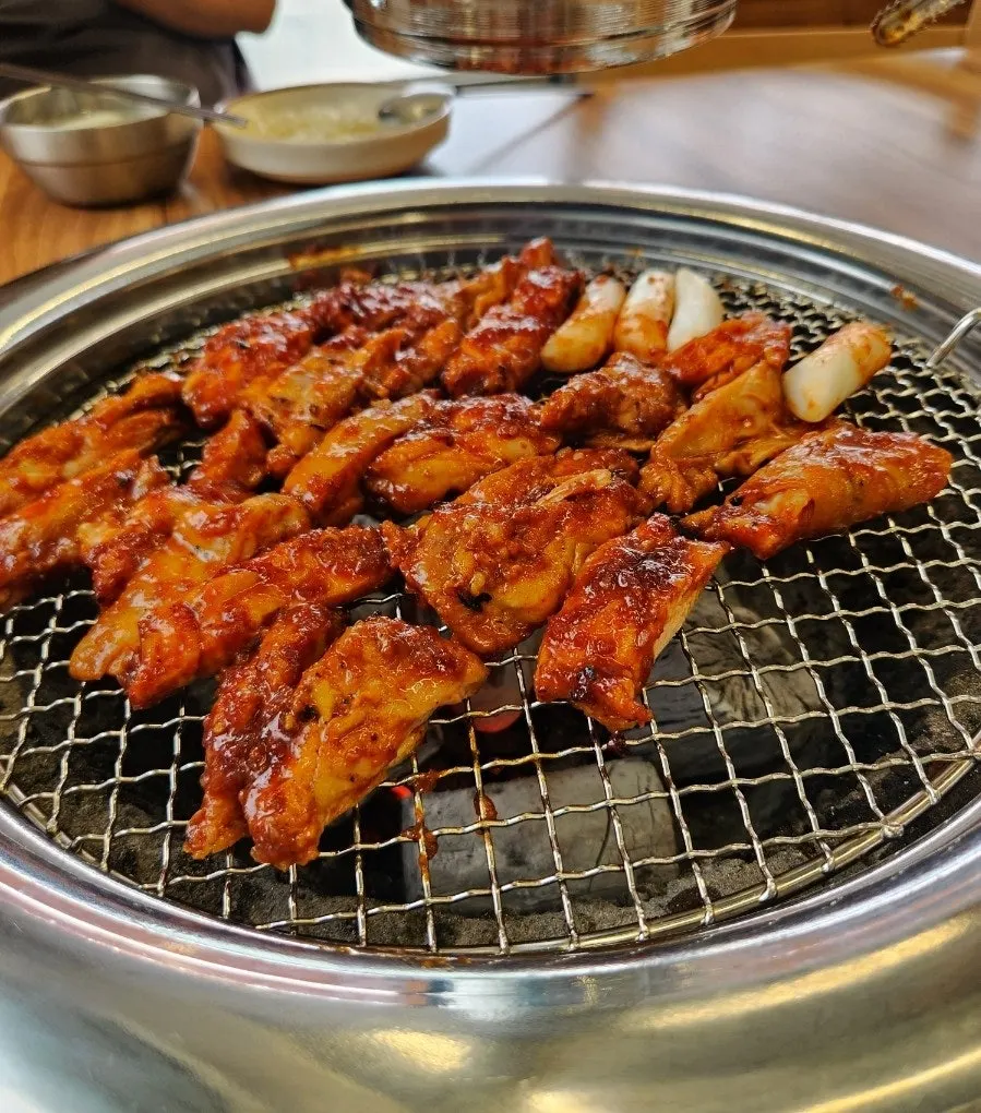 Pre-grilled charcoal dakgalbi on the grill plate