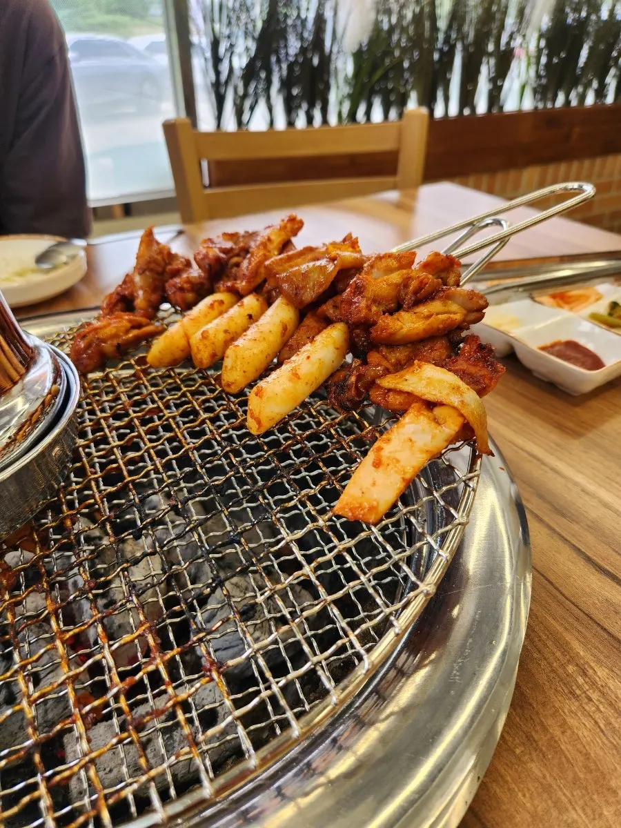 Marinated dakgalbi grilling over charcoal