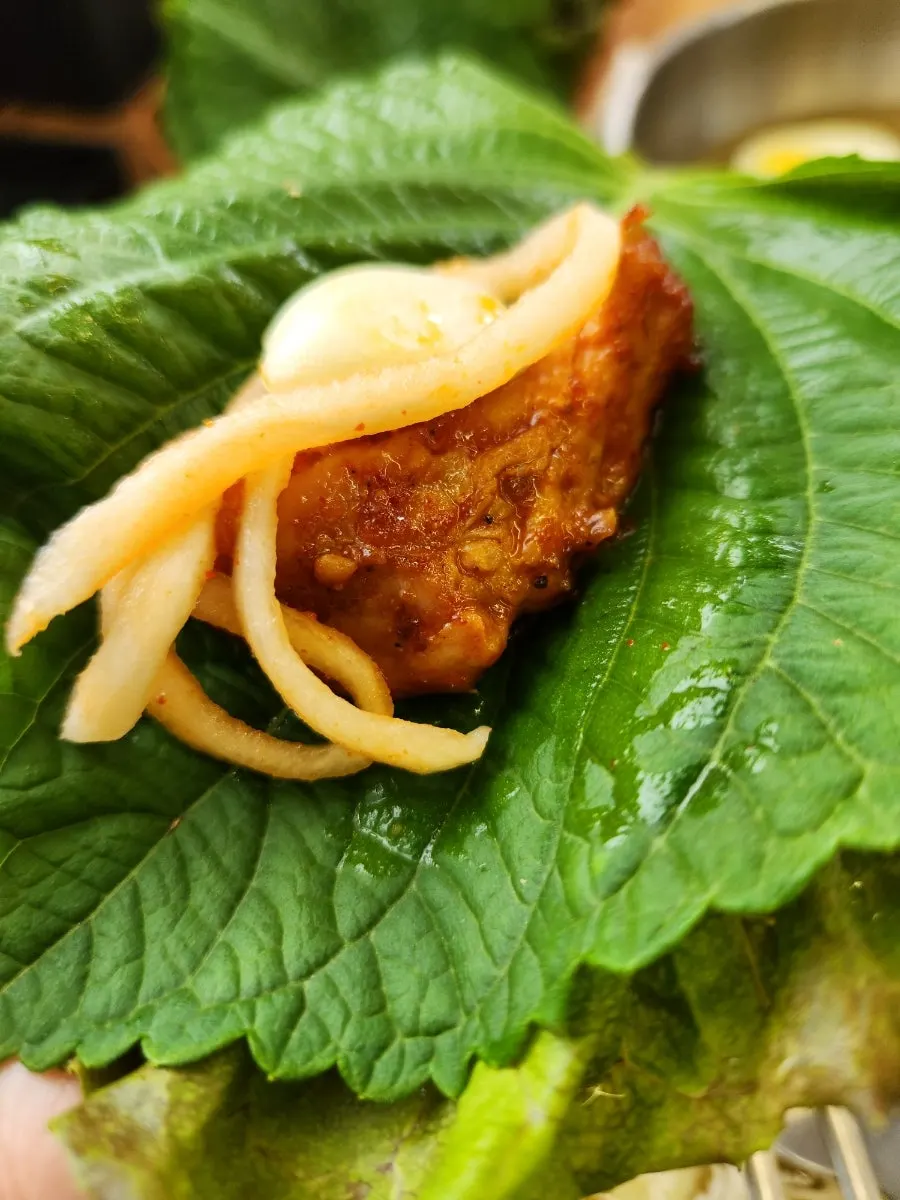 Dakgalbi placed on a lettuce leaf for wrapping