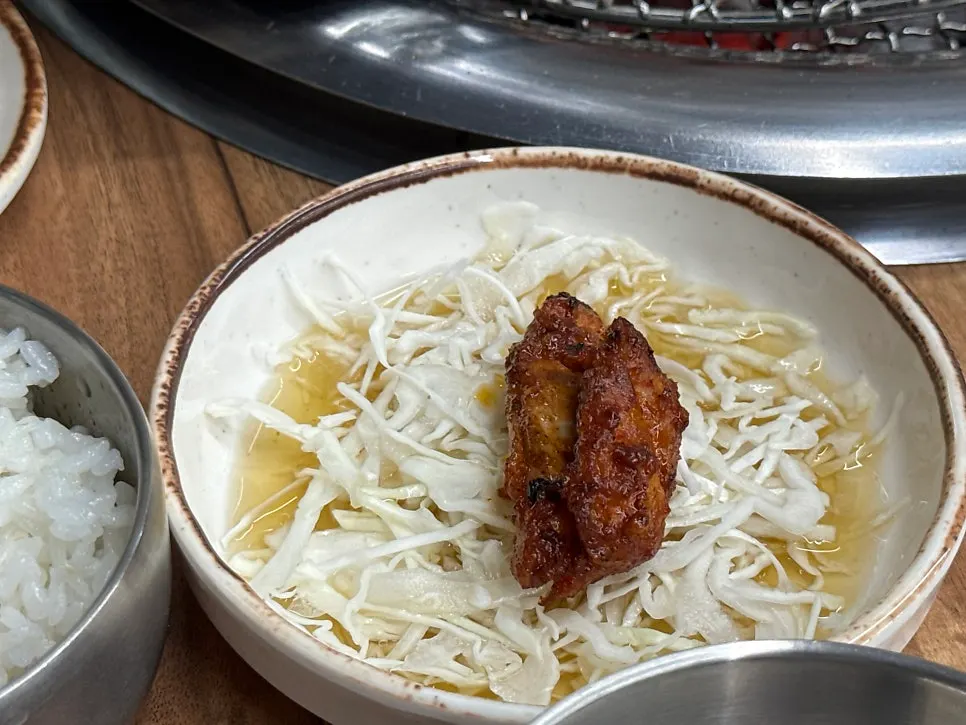 Dakgalbi served over shredded cabbage on a small plate