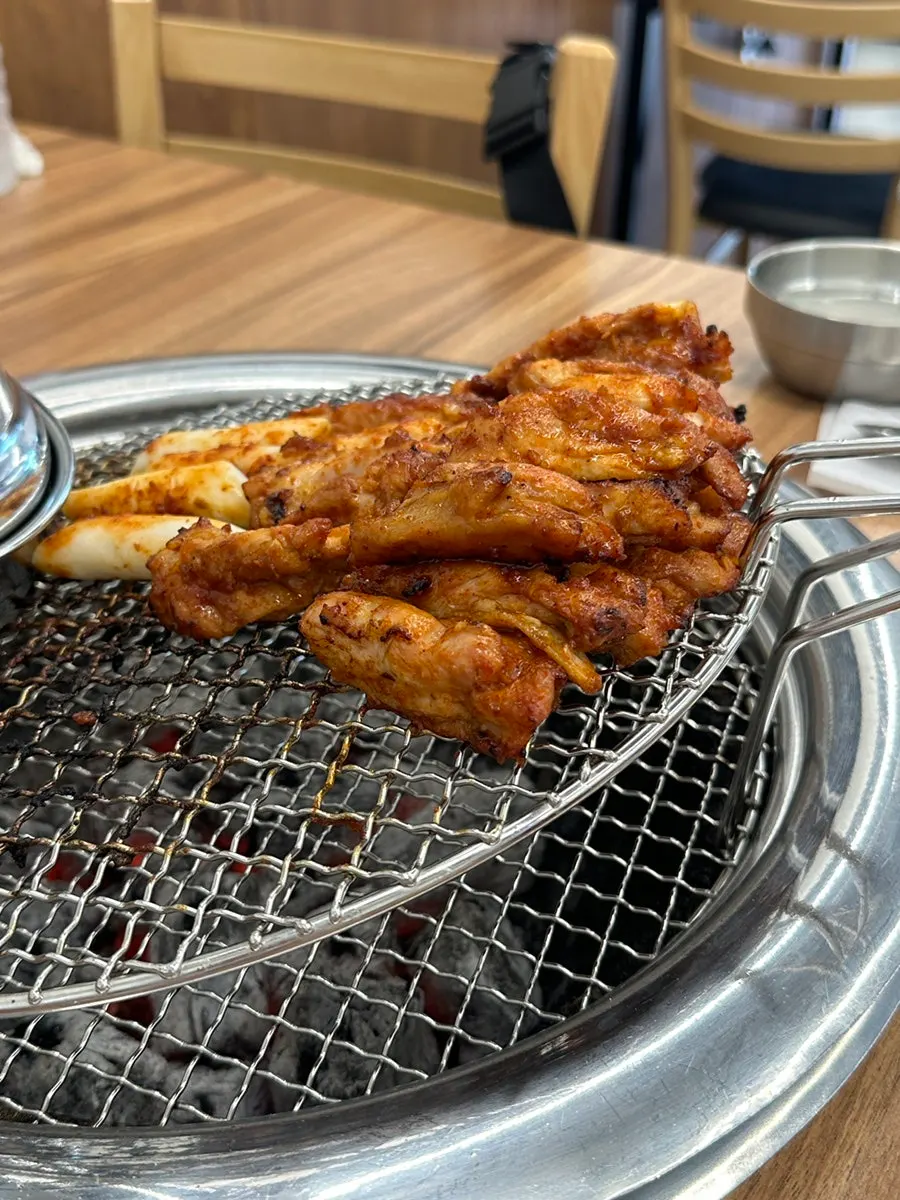 Staff pre-grilling the charcoal dakgalbi