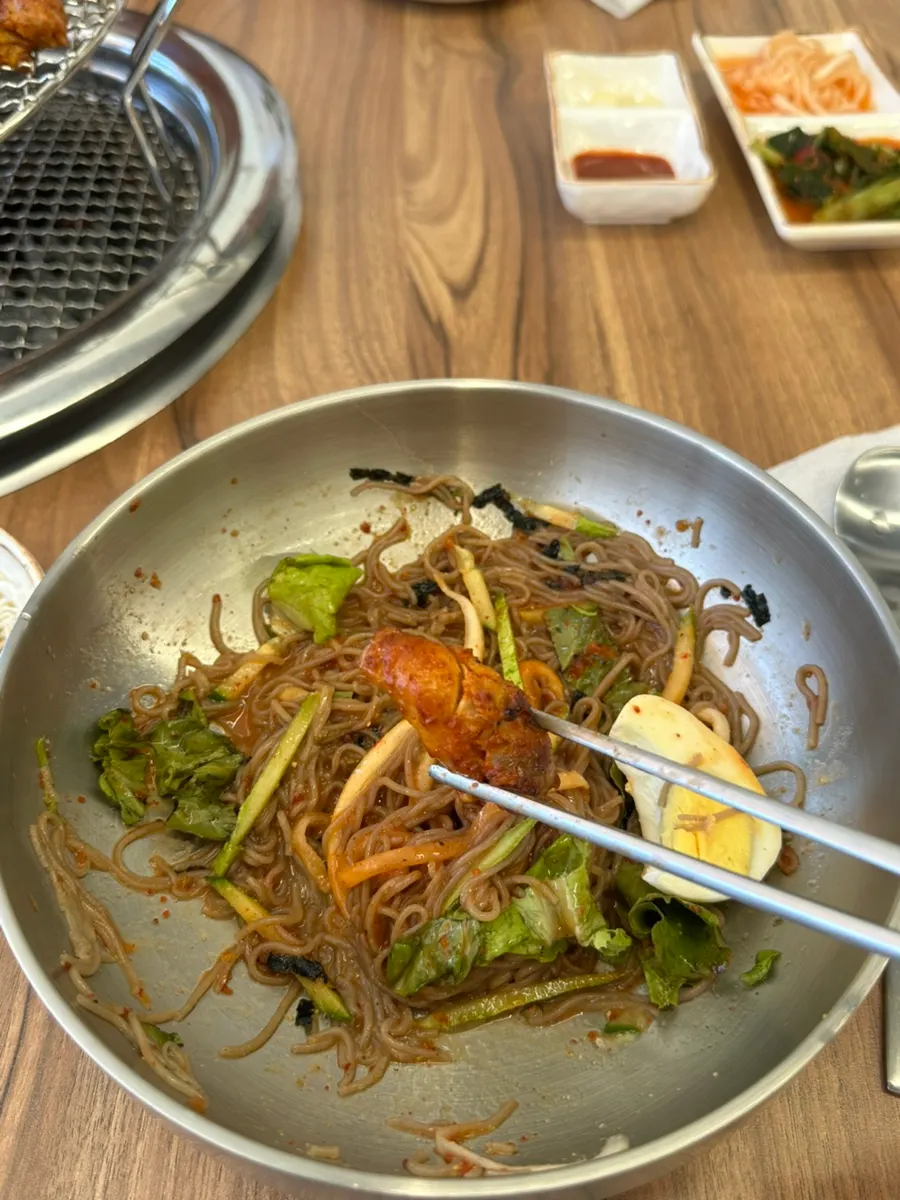 Picking up a bite of bibim makguksu noodles