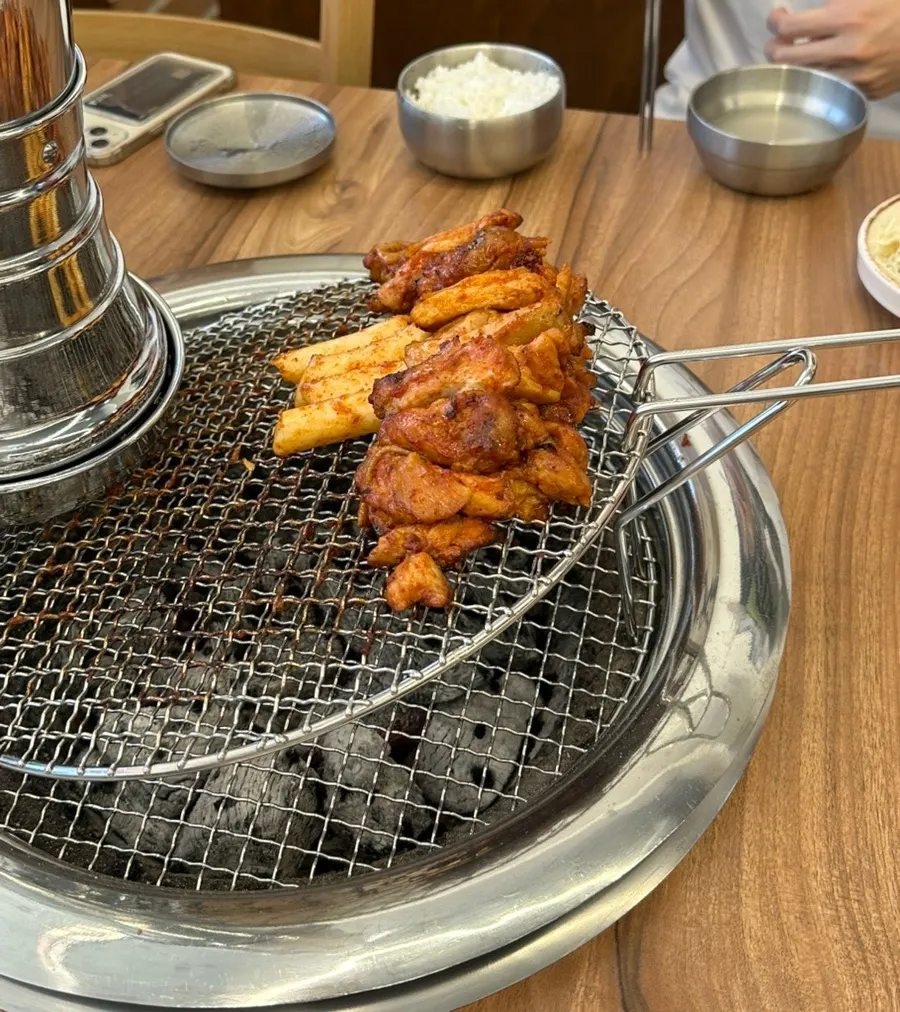 Bibim makguksu topped with a piece of charcoal dakgalbi