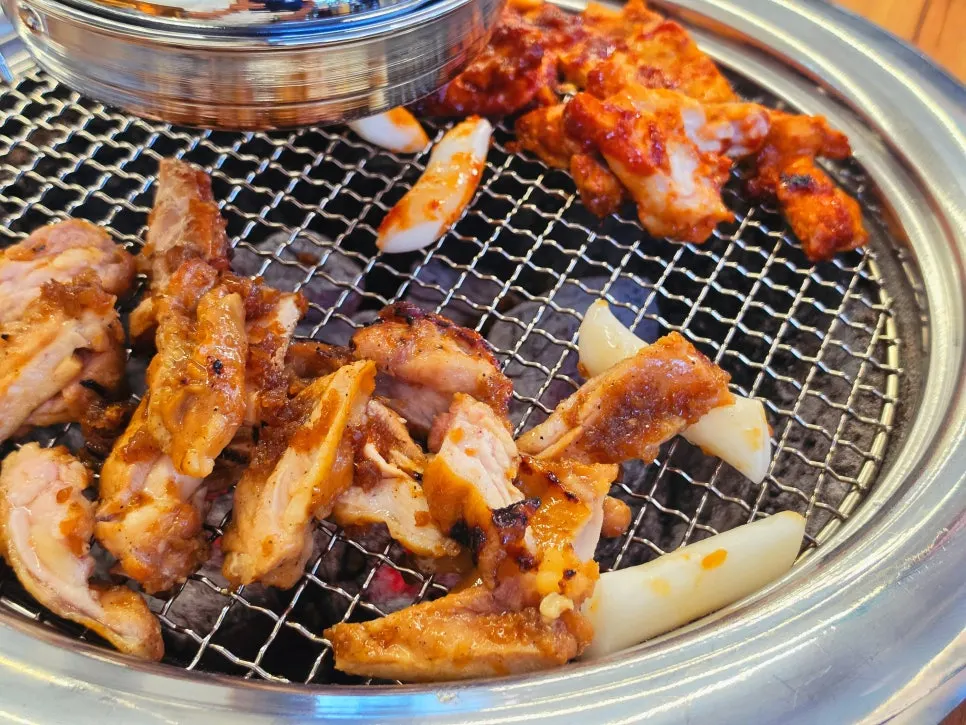 Staff member grilling dakgalbi over charcoal