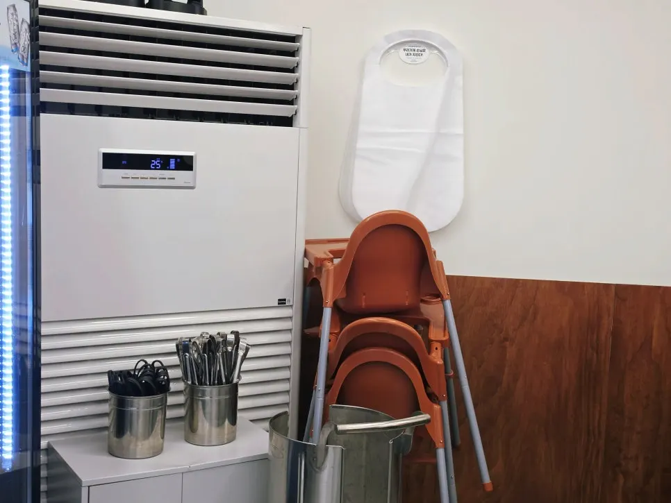 Area with disposable aprons and a high chair for kids