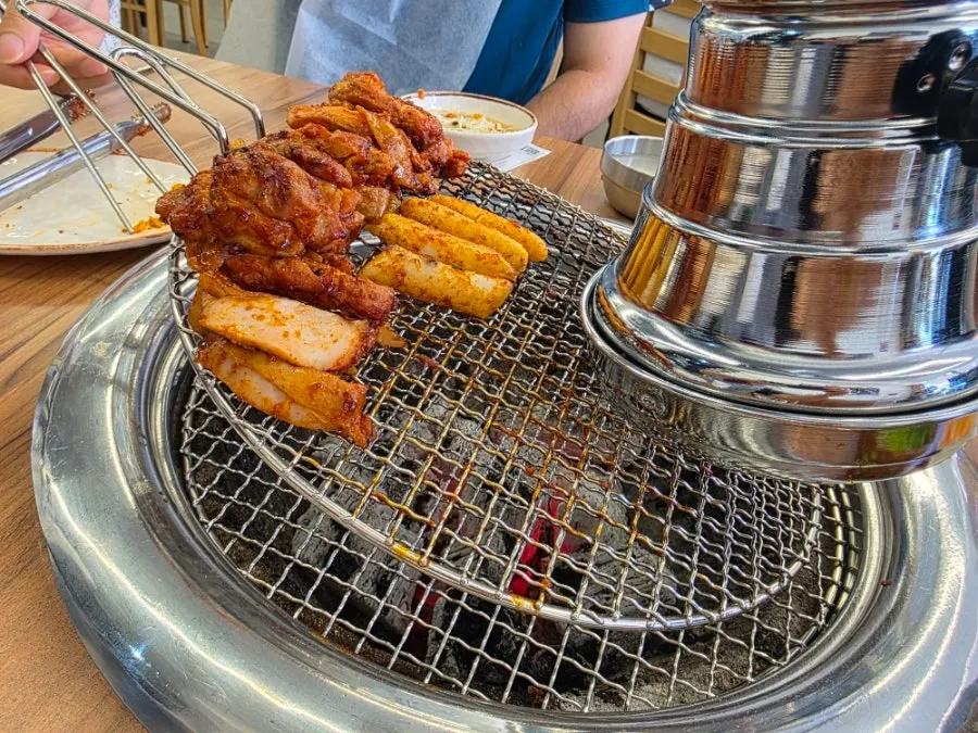 Dakgalbi gathered on one side of the grill