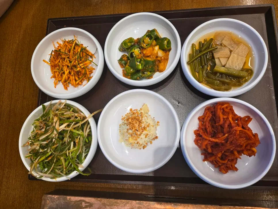 숯불 불판 양옆에 놓인 밑반찬 쟁반