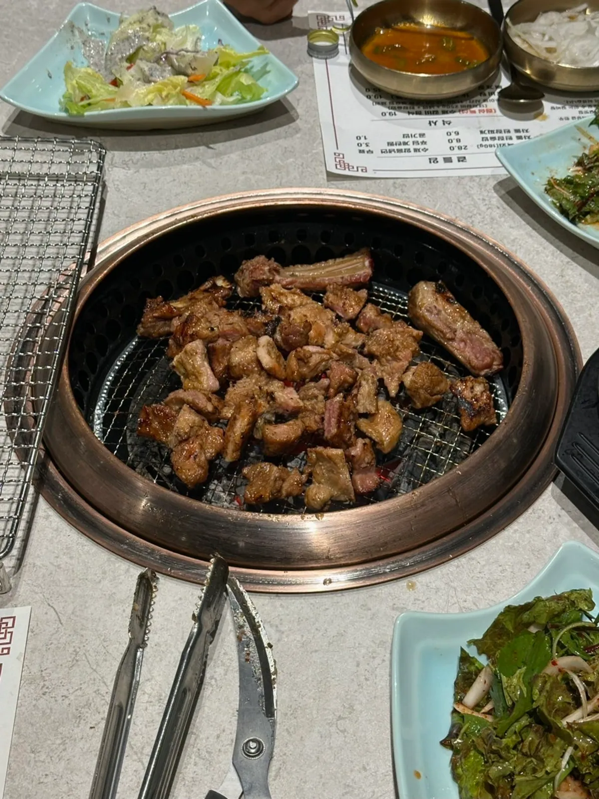 Seasoned galbi and side dishes on the grill