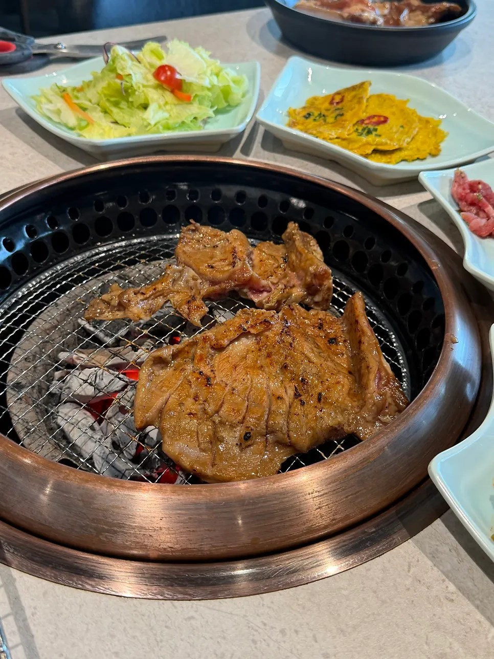 Handmade marinated galbi cooking over charcoal