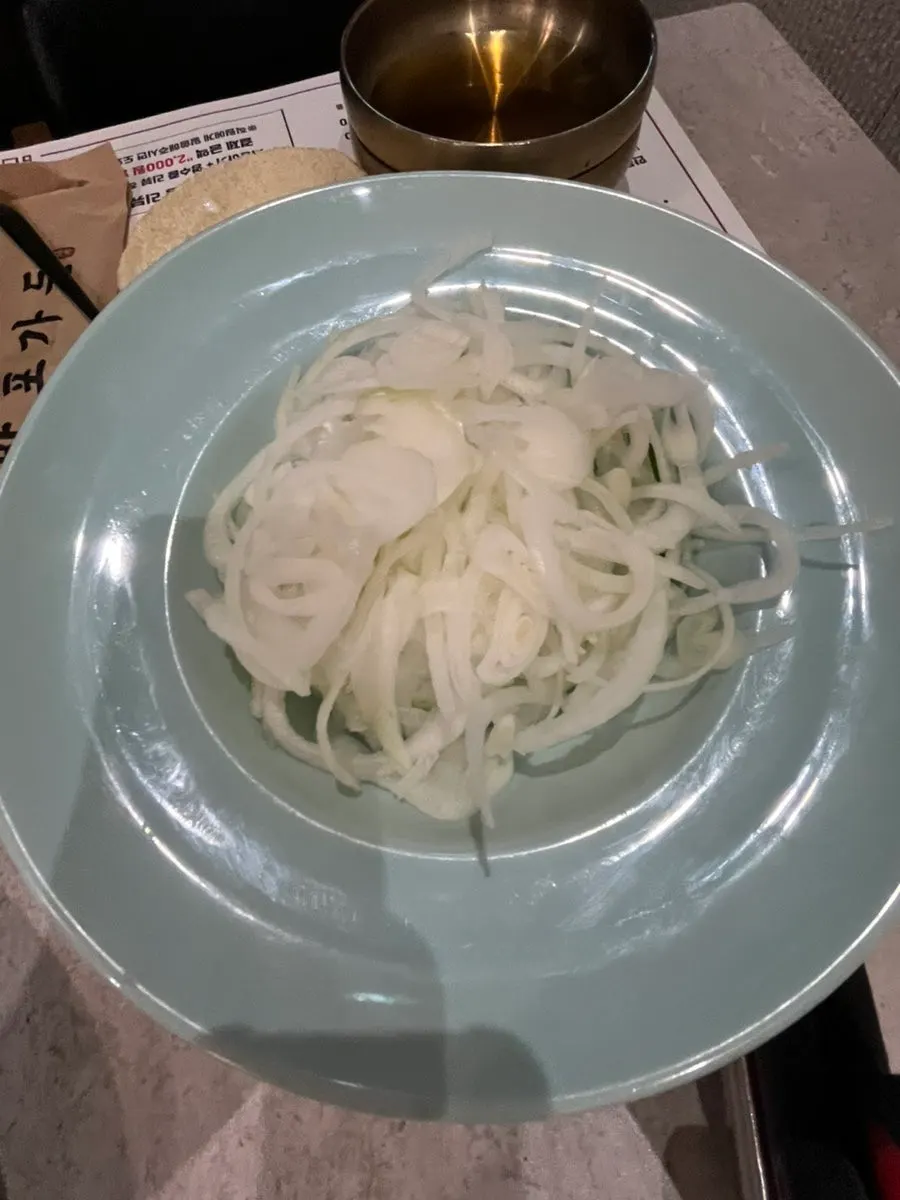 A piece of pork galbi topped with fresh vegetable salad