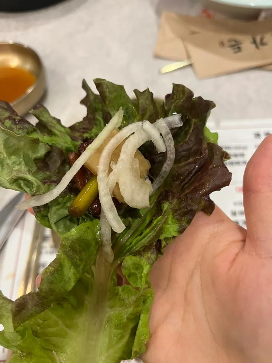 Pork galbi wrapped with side dishes in a lettuce wrap