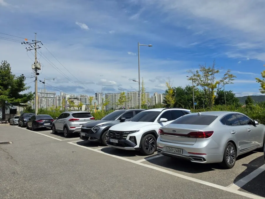 View of Manpo Garden's parking lot with two cars parked