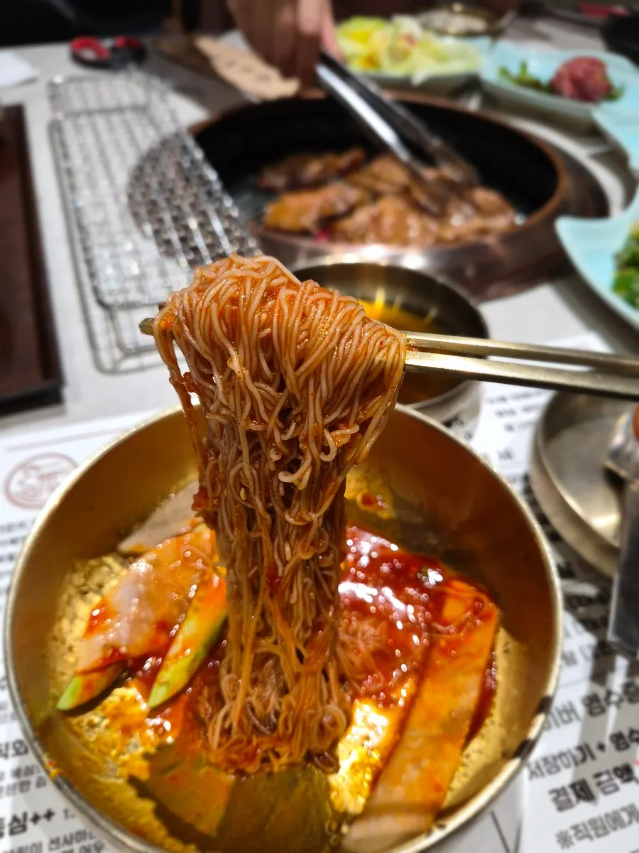Sign showing free naengmyeon with a meat order