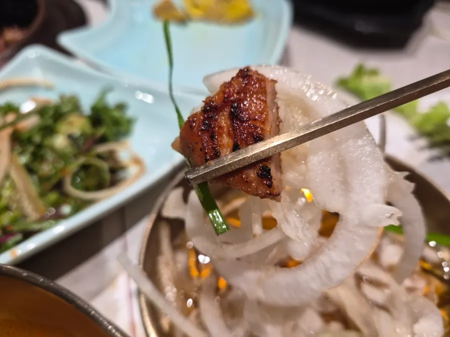 A piece of galbi dipped in onion sauce