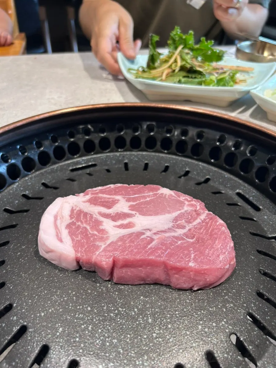Pork neck grilling on charcoal