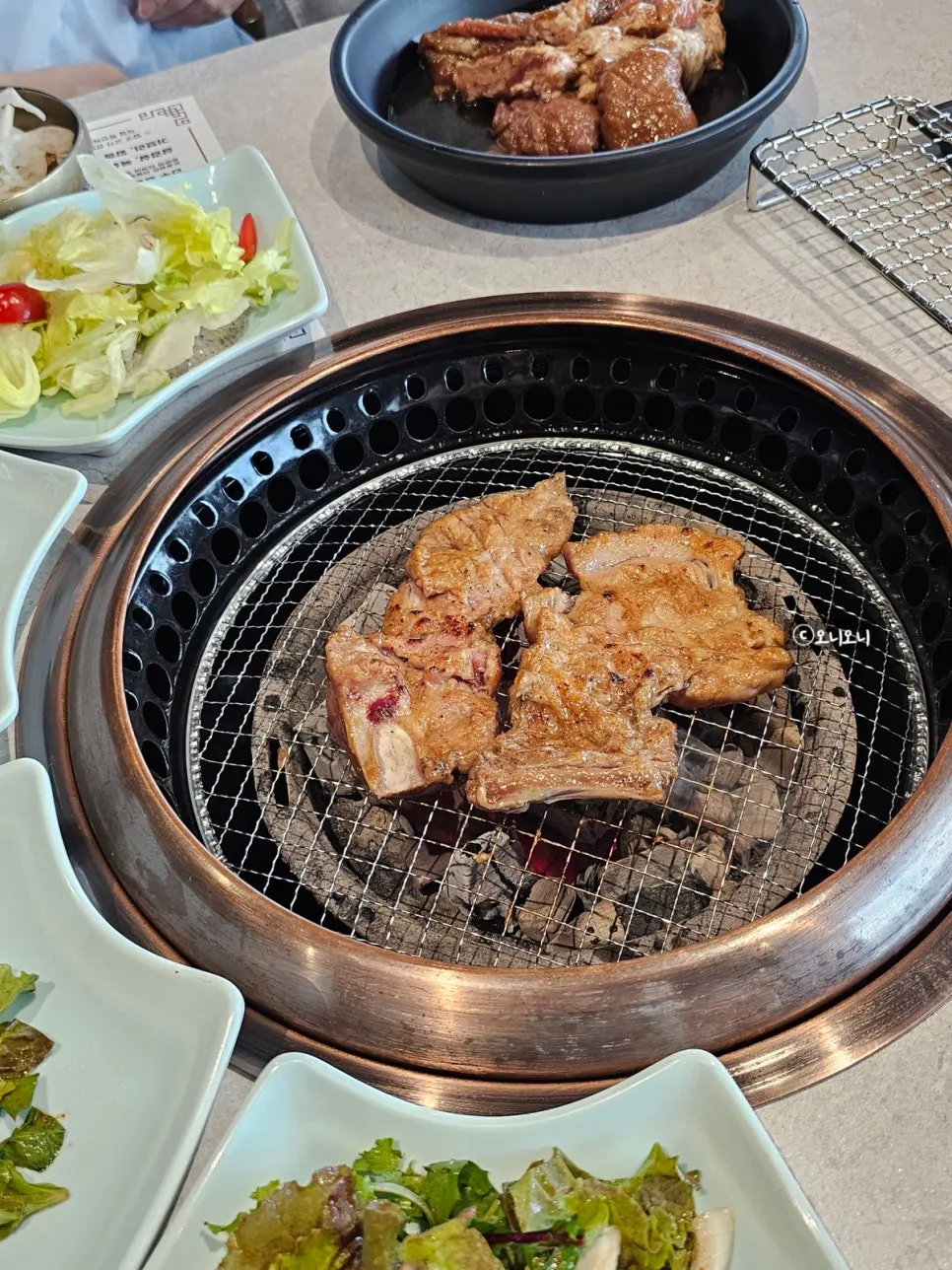 Handmade marinated pork galbi cooking over charcoal