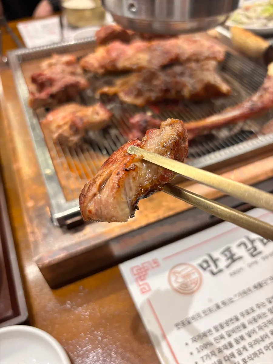 젓가락으로 집은 두툼한 돼지 생갈비