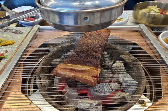 Raw ribs topped with minced garlic grilling over charcoal
