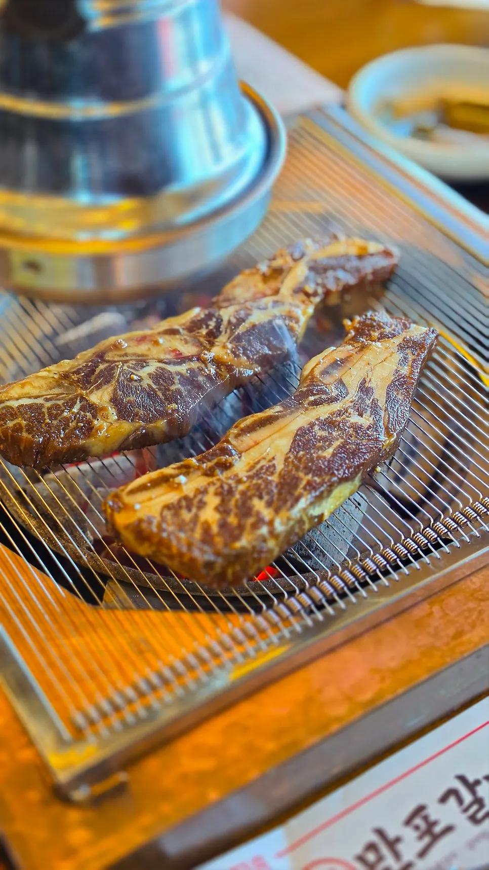 빨갛게 살아 있는 숯불과 석쇠 위 갈비