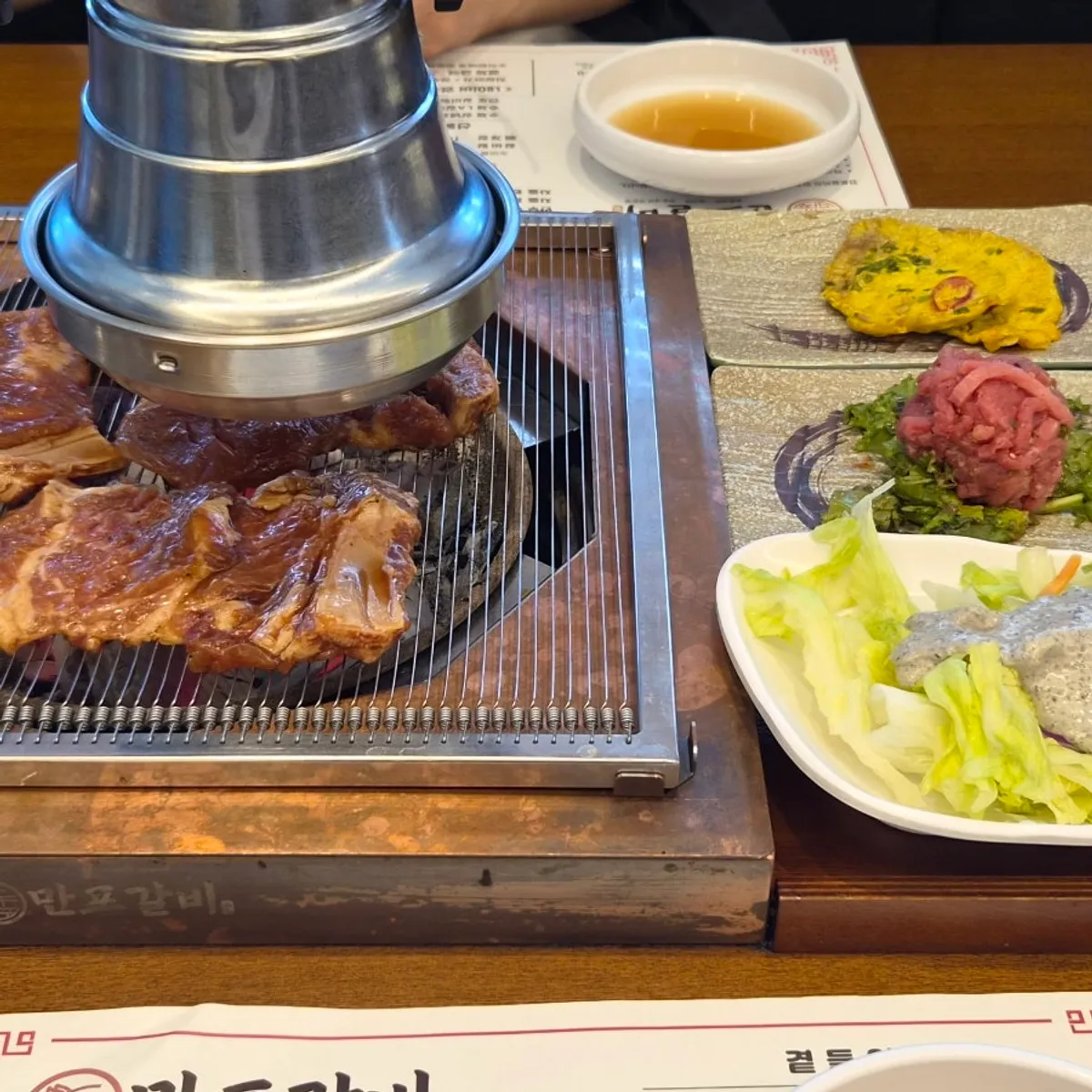 Seasoned galbi and rice dishes on the table at Manpo Galbi