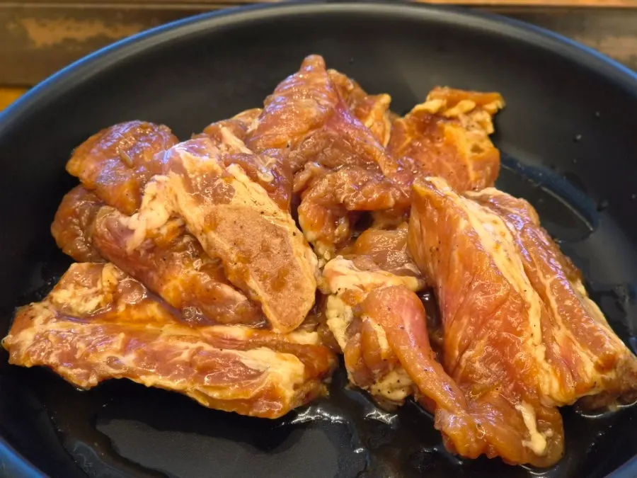 Two servings of seasoned galbi on the grill at Manpo Galbi