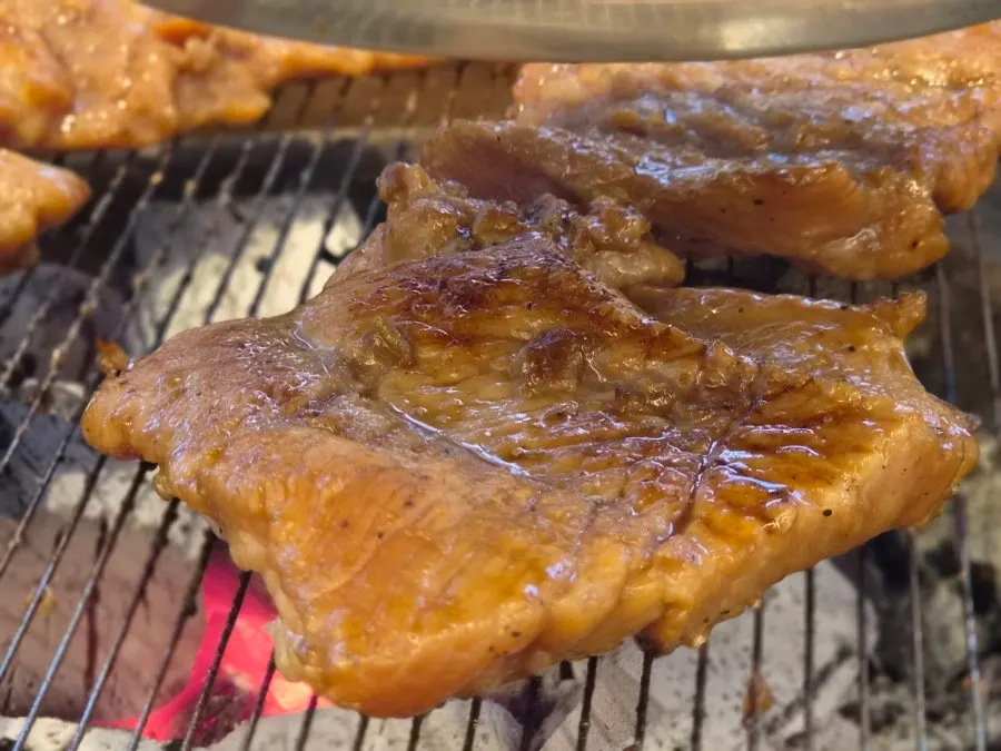 Seasoned galbi cooking on the grill