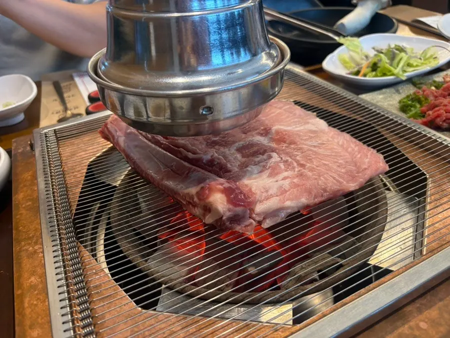 Charcoal grill with meat cooking