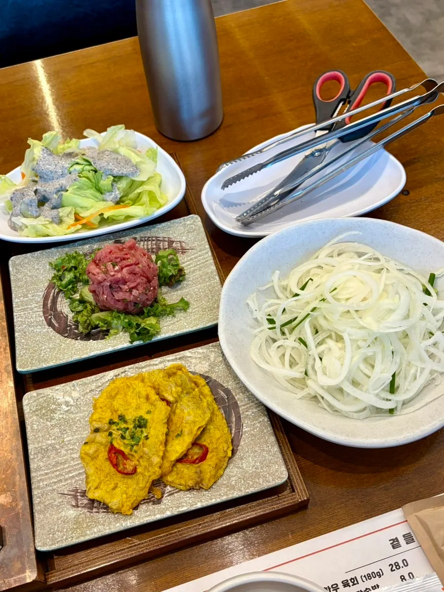 Table setting with basic side dishes, radish salad and potato salad, at Manpo Galbi