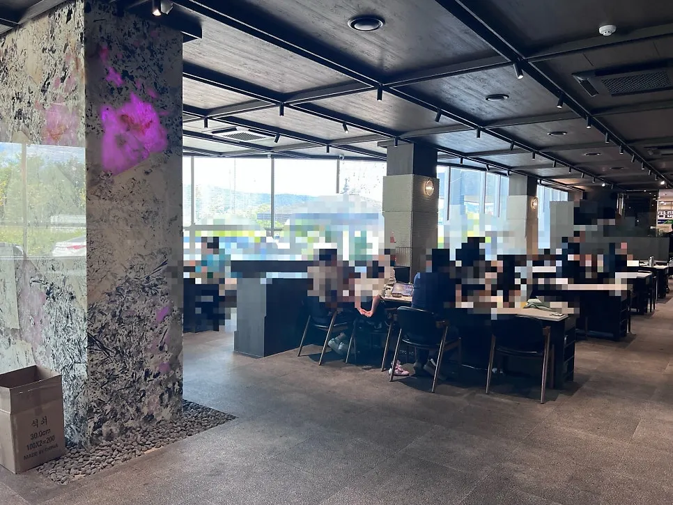 Manpo Garden's dining hall with floor-to-ceiling windows and large tables