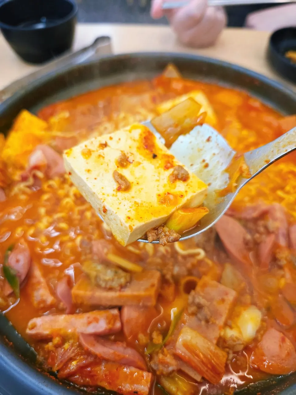 Ladleful of budae-jjigae ingredients