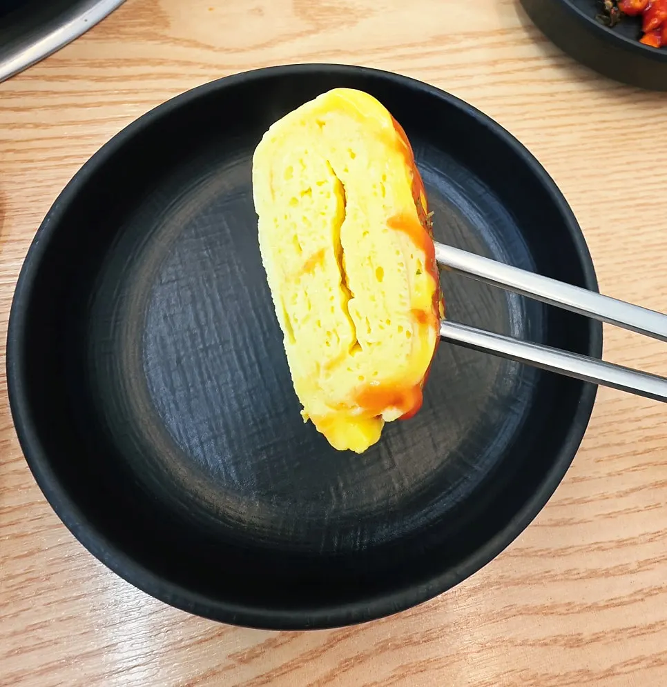 Rolled egg served alongside budae-jjigae
