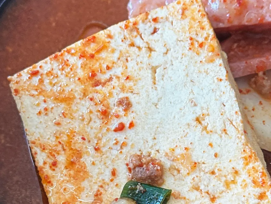 Picking out tofu from the budae-jjigae